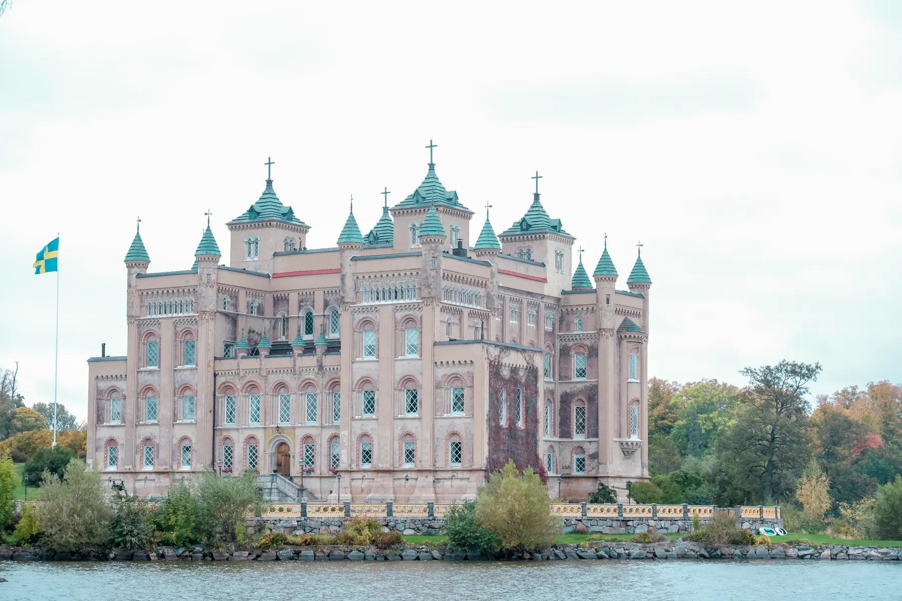 Stora Sundby slott med vatten och träd i förgrunden