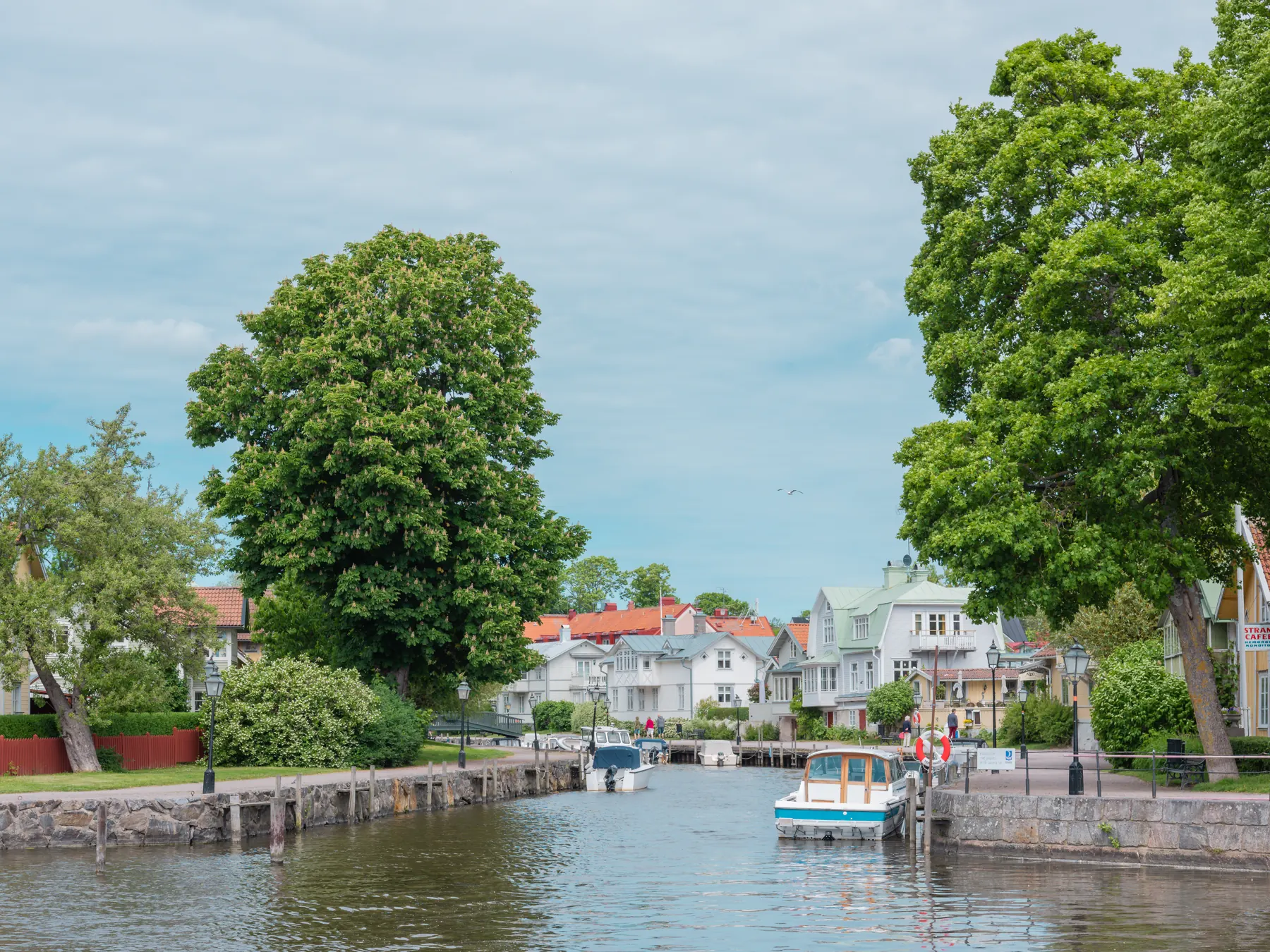 Ån i Trosa med båtar, träd och hus längs kajerna